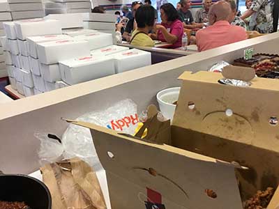 doughnut boxes in foreground; people sitting, eating and talking