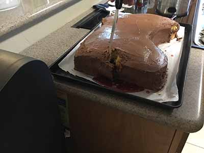 cutting into severed horse head cake revealing edible blood