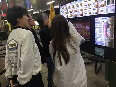 Japanese ESL students ordering food at kiosk at Sonic Drive-In