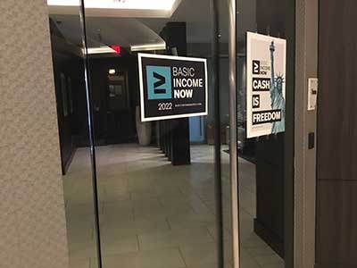 Basic Income sign on glass door entrance to theater