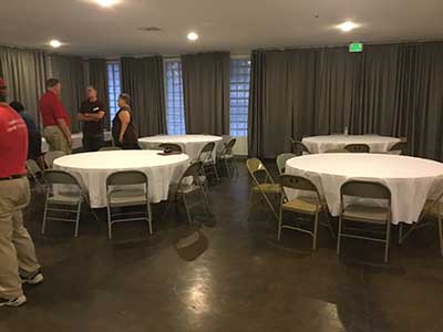 large empty round tables and some guests at Tempe Events Center