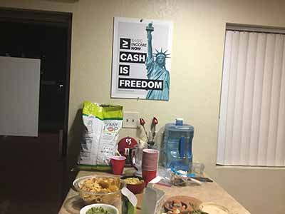 Cash is Freedom sign on door above counter laden with snacks