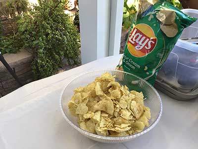 Lays potato chips in bag and bowl on food serving table