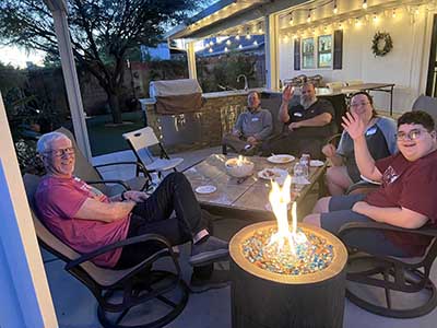 people sitting by fire at potluck dinner