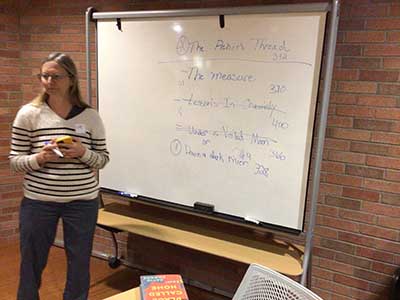 Tracy, book club leader, at whiteboard