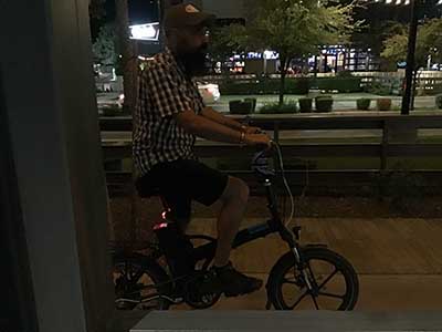 Kush posing while sitting on one of his motorized bicycles