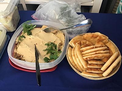 food and neighbors at potluck dinner discussion about the conflict in Israel and Gaza