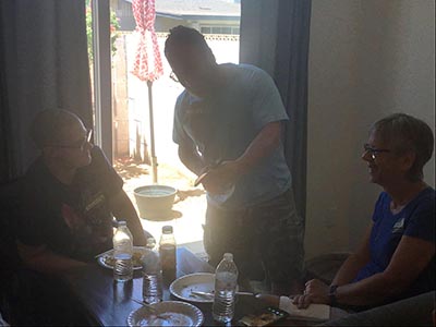 cat-loving guest showing other guests a video of his cat at the Meow-Mixer cat-lovers potluck lunch event