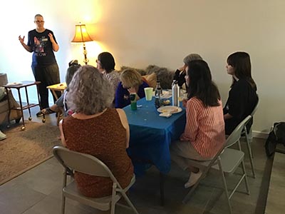 event host Diane speaking to guests at the Meow-Mixer cat-lovers potluck lunch event