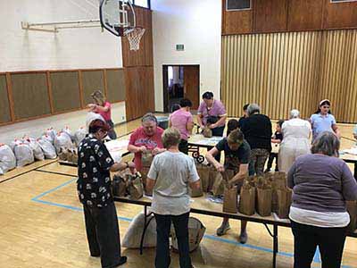 neighbors volunteering at Women4Women Tempe service project (packing party)