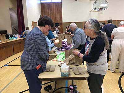 neighbors volunteering at Women4Women Tempe service project (packing party)