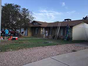 neighbors gather to scrape and paint trim on home of elderly neighbor Nellice Reidhead