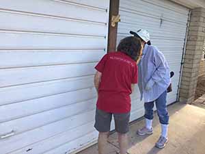 neighbors gather to scrape and paint trim on home of elderly neighbor Nellice Reidhead