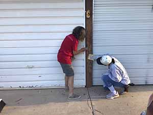 neighbors gather to scrape and paint trim on home of elderly neighbor Nellice Reidhead