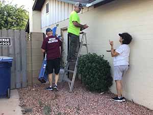 neighbors gather to scrape and paint trim on home of elderly neighbor Nellice Reidhead