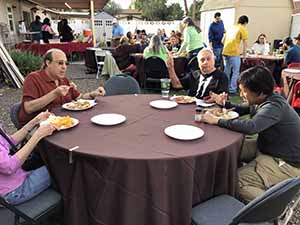 neighbors gather at for Thanksgiving Day potluck dinner