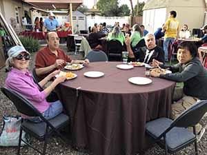 neighbors gather at for Thanksgiving Day potluck dinner