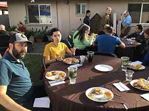 neighbors gather at for Thanksgiving Day potluck dinner