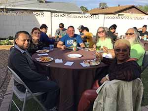 neighbors gather at for Thanksgiving Day potluck dinner