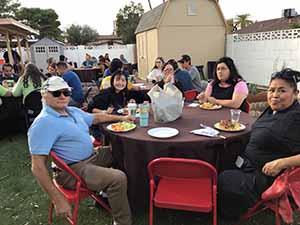 neighbors gather at for Thanksgiving Day potluck dinner