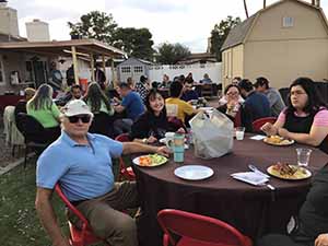 neighbors gather at for Thanksgiving Day potluck dinner