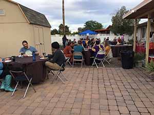 neighbors gather at for Thanksgiving Day potluck dinner