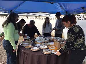 neighbors gather at for Thanksgiving Day potluck dinner