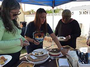 neighbors gather at for Thanksgiving Day potluck dinner