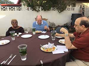 neighbors gather at for Thanksgiving Day potluck dinner