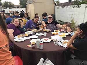 neighbors gather at for Thanksgiving Day potluck dinner