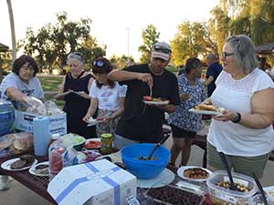 neighbors gather at park for potluck dinner birthday party