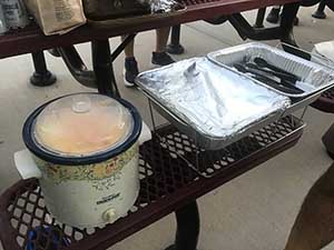 neighbors gather at park for potluck dinner birthday party