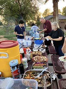 neighbors gather at park for potluck dinner birthday party