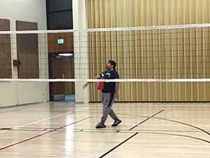 neighbors gather to play indoor volleyball