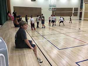 neighbors gather to play indoor volleyball